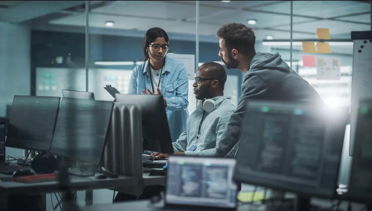 Team sitting around a group of computers